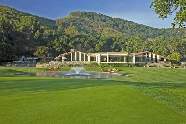 view of community featuring a water and mountain view and a lawn