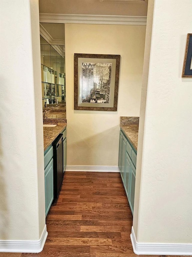 bar featuring dishwashing machine, dark hardwood / wood-style flooring, and ornamental molding