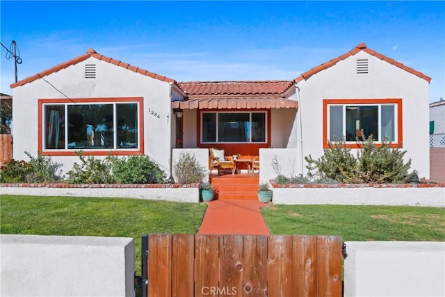 mediterranean / spanish home featuring a front yard