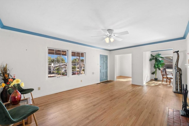 living room featuring ornamental molding, light hardwood / wood-style floors, and ceiling fan