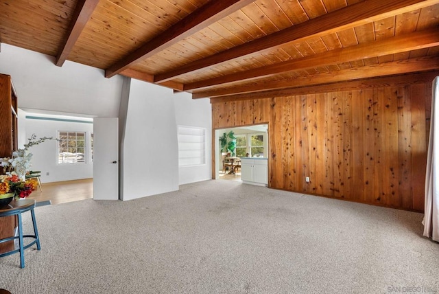 unfurnished living room with wooden walls, wooden ceiling, and beam ceiling