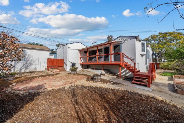 back of house with a deck and a patio area