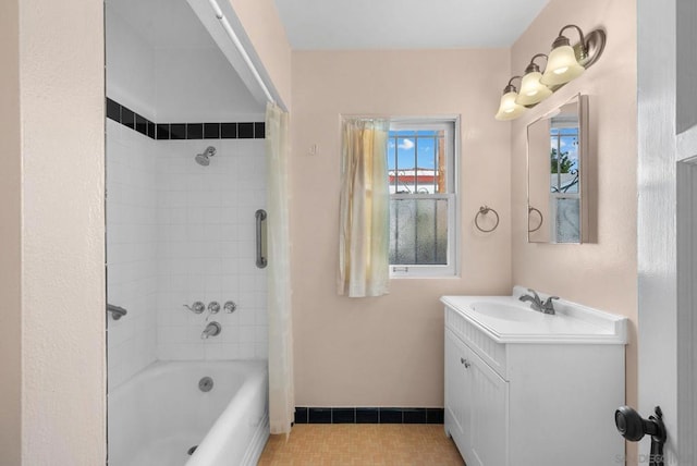 bathroom featuring tiled shower / bath and vanity