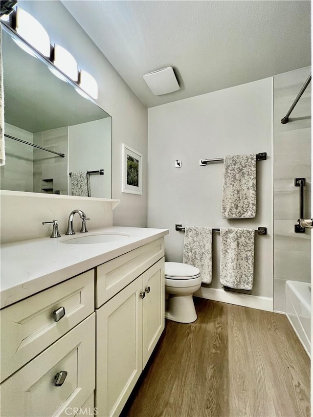 bathroom with vanity, wood finished floors, and toilet