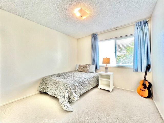 bedroom featuring carpet and a textured ceiling