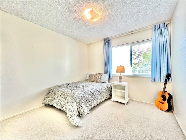 bedroom featuring a textured ceiling, carpet flooring, and baseboards