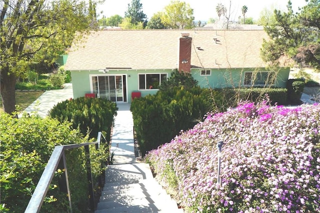 view of front of property featuring a chimney and stucco siding