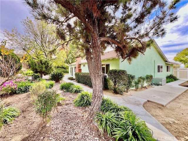 view of side of property with fence and stucco siding