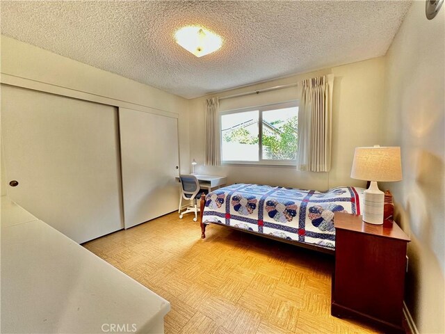 bedroom with a textured ceiling and a closet