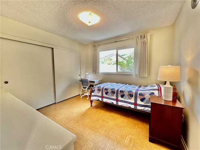 bedroom with a textured ceiling and a closet