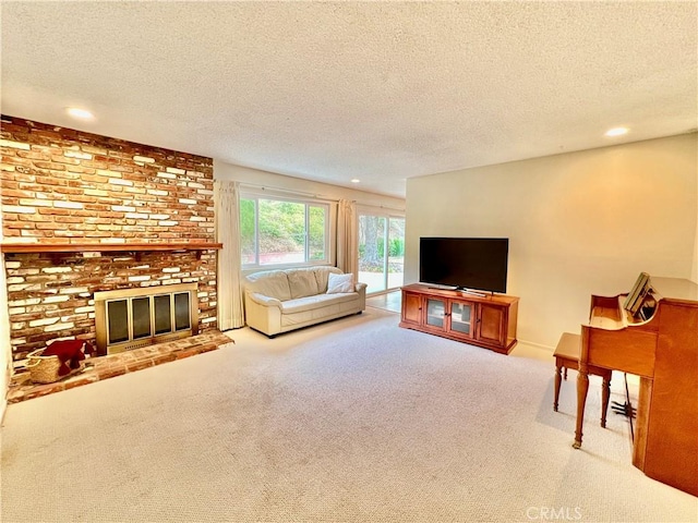 carpeted living room featuring a brick fireplace and a textured ceiling