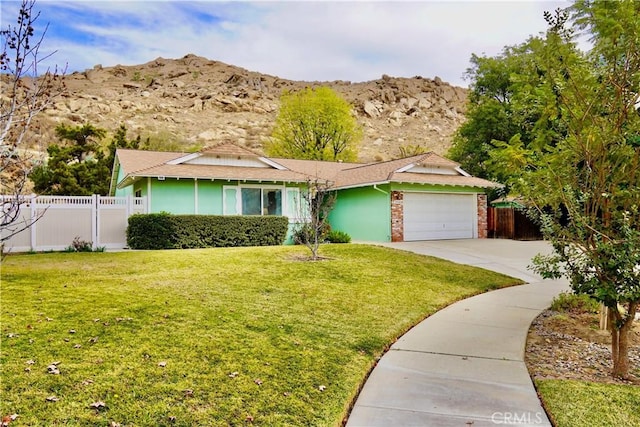 ranch-style home featuring a garage, a mountain view, and a front lawn