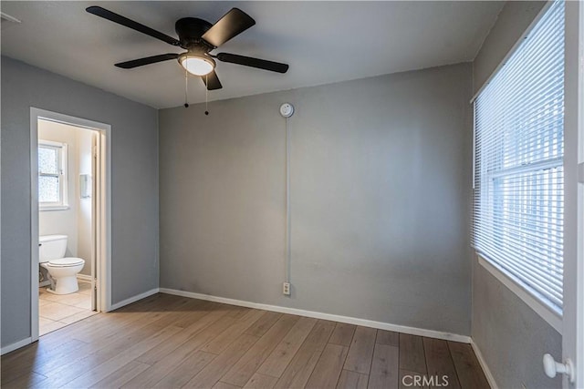 unfurnished bedroom with ensuite bathroom, ceiling fan, and light hardwood / wood-style floors