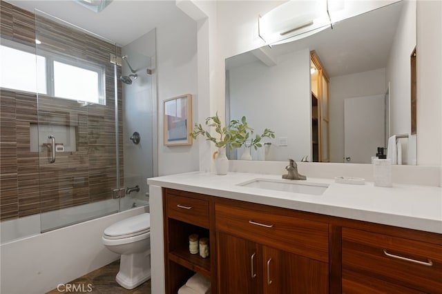 full bathroom with enclosed tub / shower combo, vanity, and toilet