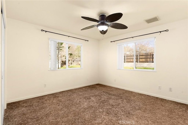 carpeted spare room featuring ceiling fan