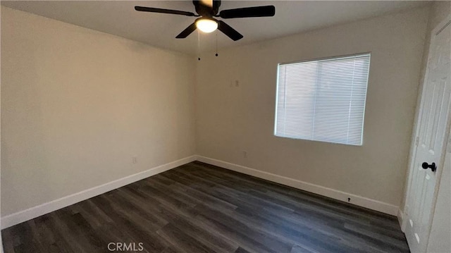 spare room with dark wood-type flooring and ceiling fan