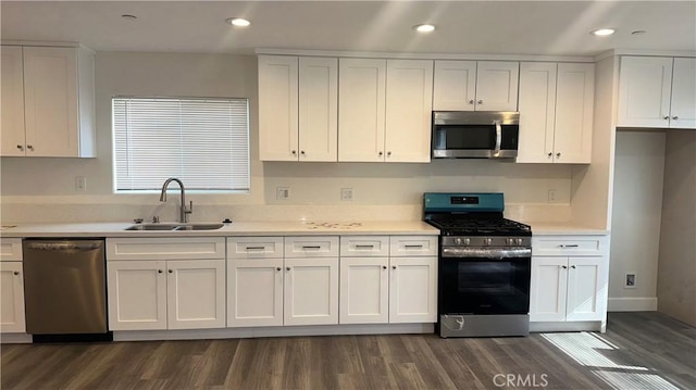 kitchen featuring white cabinetry, sink, dark hardwood / wood-style flooring, and appliances with stainless steel finishes