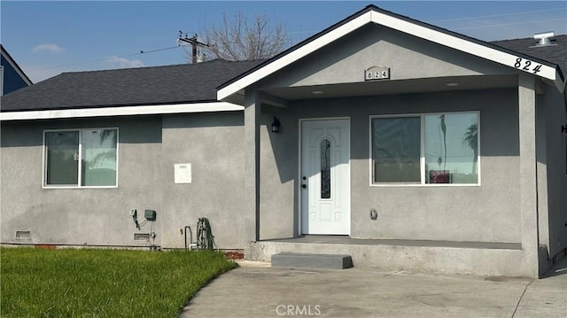 property entrance with a yard and a patio