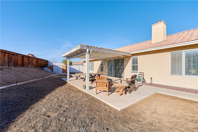 rear view of house with a storage shed and a patio