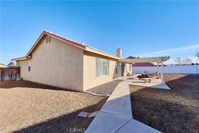 back of property featuring a pergola and a patio area