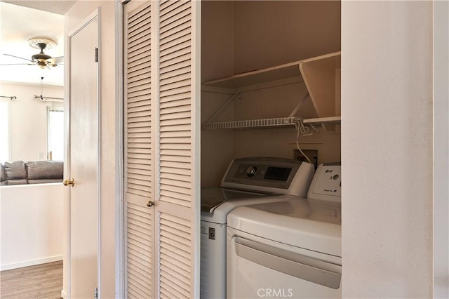 laundry area with ceiling fan, washing machine and clothes dryer, and light hardwood / wood-style floors