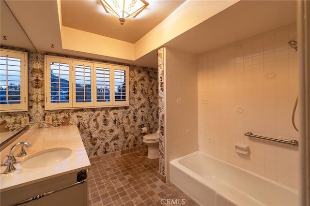 full bathroom with vanity, toilet, and tiled shower / bath combo