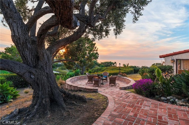 yard at dusk featuring a patio