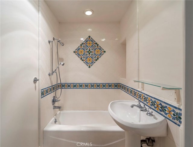 bathroom featuring tile walls, sink, and tiled shower / bath