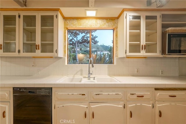 kitchen with backsplash, tile countertops, sink, and dishwasher