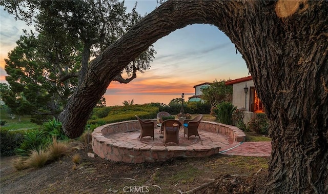 yard at dusk featuring a patio