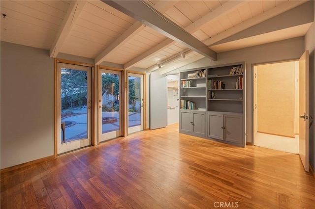 interior space with lofted ceiling with beams and light wood-type flooring