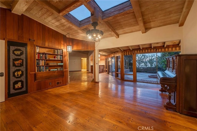 living room with lofted ceiling with skylight, hardwood / wood-style floors, wood ceiling, and wood walls