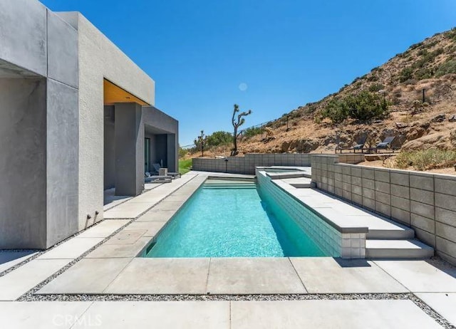 view of pool with a patio area and an in ground hot tub