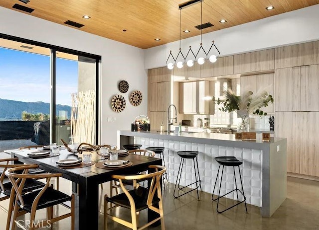 dining area with a mountain view, wooden ceiling, and sink