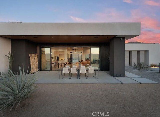 back house at dusk with a patio area