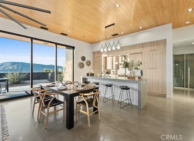 dining space with a mountain view and wood ceiling