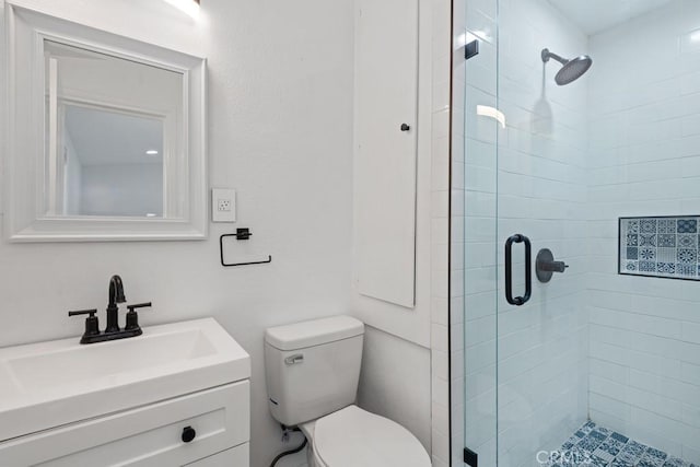 bathroom with vanity, an enclosed shower, and toilet