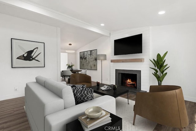 living room featuring vaulted ceiling with beams, a large fireplace, and dark hardwood / wood-style floors