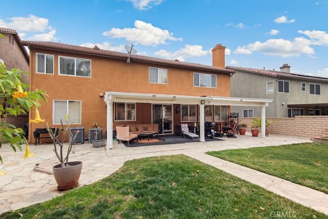 rear view of property with a lawn and a patio area