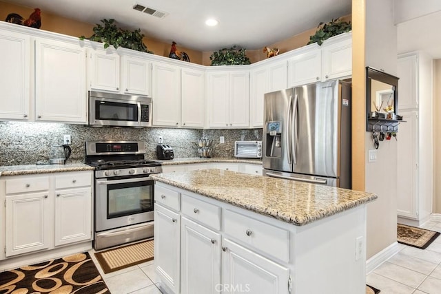 kitchen featuring white cabinetry, stainless steel appliances, and light tile patterned floors