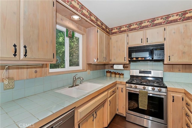 kitchen with sink, gas range, tile countertops, and light brown cabinets