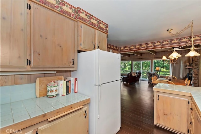 kitchen featuring pendant lighting, tile countertops, light brown cabinetry, white fridge, and dark wood-type flooring