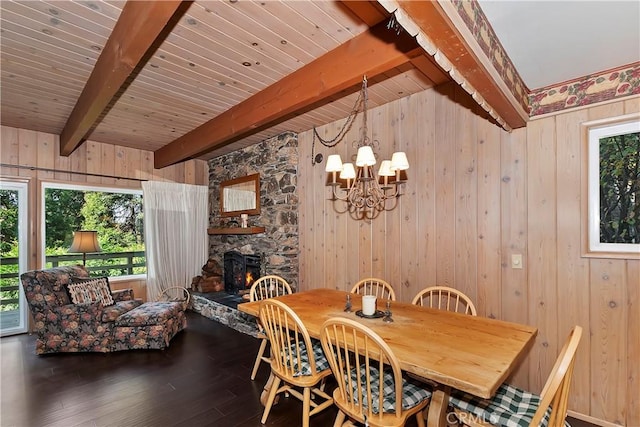 dining room featuring hardwood / wood-style floors, beam ceiling, plenty of natural light, and a fireplace