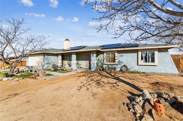 ranch-style home with a patio and solar panels