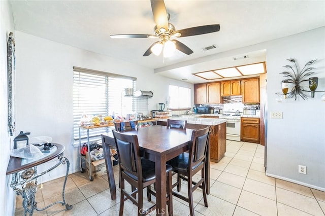 tiled dining area with sink and ceiling fan