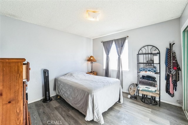 bedroom featuring hardwood / wood-style flooring and a textured ceiling