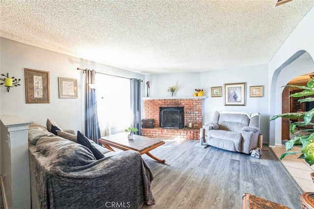 living room featuring a fireplace, hardwood / wood-style floors, and a textured ceiling