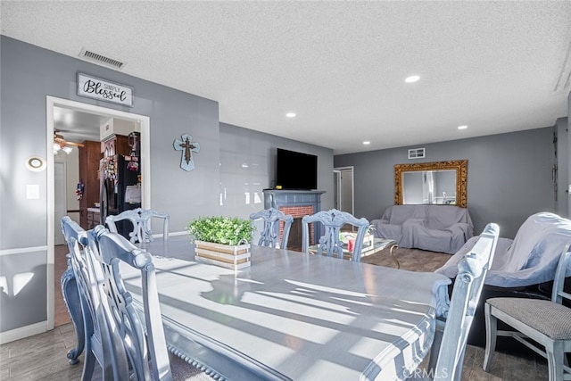 dining room featuring hardwood / wood-style flooring and a textured ceiling