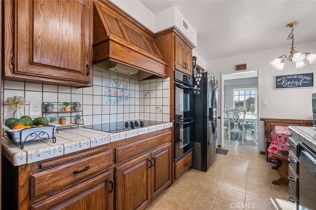 kitchen with decorative backsplash, custom exhaust hood, tile counters, light tile patterned floors, and black appliances