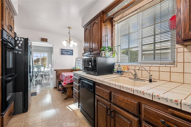 kitchen featuring light tile patterned flooring, decorative light fixtures, sink, a notable chandelier, and black appliances